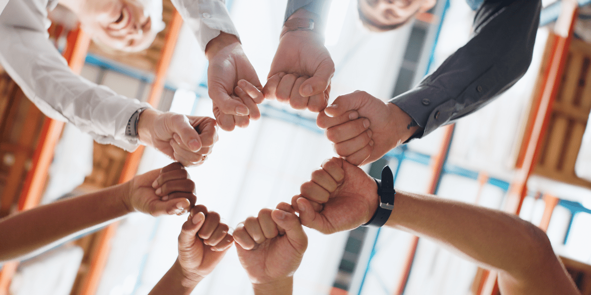 Small-group-teambuilding-circle-of-fists-shutterstock_2472842693